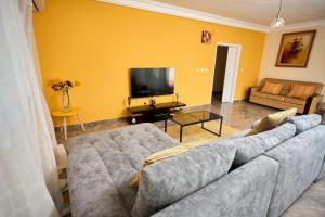 a living room with a couch and a tv at La Samurai House Assinie in Assinie