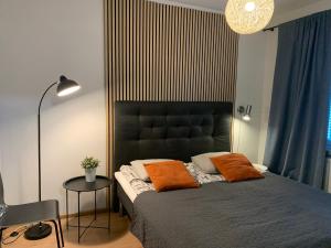 a bedroom with a bed with two orange pillows at StarHomes Oulu, double in Oulu