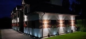 a building with flowers on the side of it at night at Pod Dachem Tykocin in Tykocin +7 photos