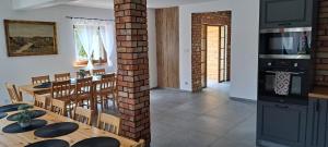 a kitchen and dining room with a table and chairs at Pod Dachem Tykocin in Tykocin