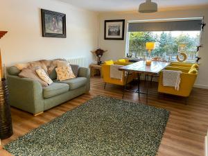 a living room with a couch and a table at Stags View in Invergarry +7 photos