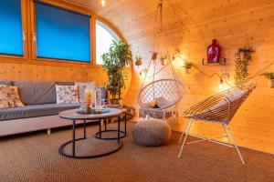a living room with a couch and a table and chairs at L'oasis des Coccinelles - 2 gîtes insolites ultra cosy in Sainte-Croix-aux-Mines