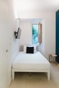 a white bed in a room with a window at La balza di Scilla in Scilla