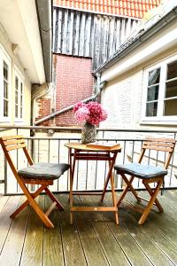 a table with two chairs and a vase of flowers on a porch at Das Stader Zuhause in Stade