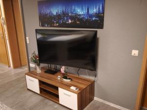 a flat screen tv sitting on top of a wooden entertainment center at NEU! Ferienwohnung Gondwana in Schiffweiler