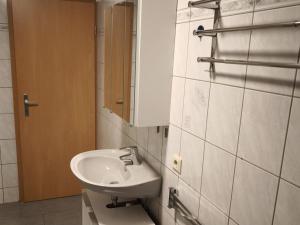 a bathroom with a sink and a mirror at NEU! Ferienwohnung Gondwana in Schiffweiler +11 photos