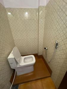 a bathroom with a toilet and a shower at Elowen Suites in Manjeri