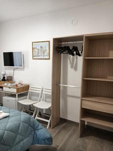 a room with a bed and a kitchen with a refrigerator at La Casa del Postino in Farigliano