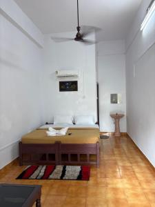 a bedroom with a bed in a white room at Elowen Suites in Manjeri