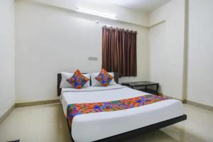 a bedroom with a large bed in a room at FabHotel Krishna Inn in Hinjewadi