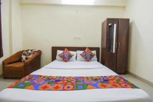 a bedroom with a bed with a colorful quilt on it at FabHotel Krishna Inn in Hinjewadi