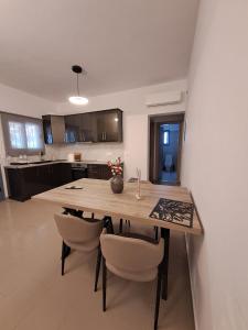 a kitchen with a wooden table and some chairs at Nenes Comfort Apartment in Koroni