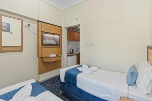 a hotel room with two beds and a kitchen at Wahet Al Deafah Hotel in Mecca