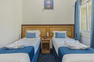a hotel room with two beds with blue pillows at Wahet Al Deafah Hotel in Mecca