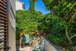 a patio with a table and chairs and plants at Rooms Feme in Trogir