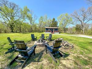 a group of chairs sitting around a fire pit at Cozy Tiny Home Cabin in Eva, TN in Eva