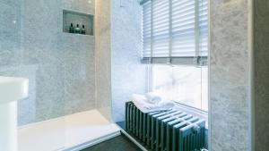 a bathroom with a shower with a radiator and a window at Number eight in Beaumaris +67 photos