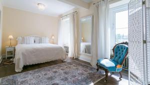 a bedroom with a bed and a blue chair at Number eight in Beaumaris
