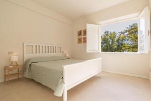 a bedroom with a bed and a window at Casale sul Mare - Grilli 2 in Lacona
