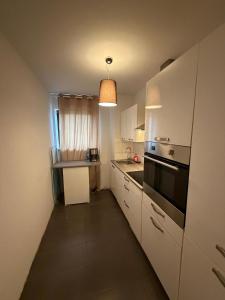 a kitchen with white cabinets and a stove top oven at Saarlouis2 in Saarlouis