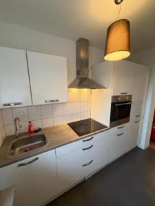 a kitchen with white cabinets and a sink and a lamp at Saarlouis2 in Saarlouis +17 photos