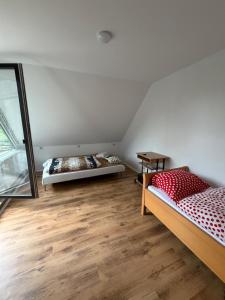 two beds in a room with wooden floors at Saarlouis2 in Saarlouis