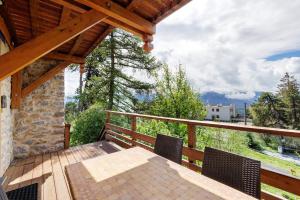 a wooden porch with a table and chairs on a deck at Lis Martagon in Font-Romeu