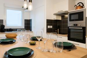 a table with wine glasses and plates on it at T3 moderne- Climatisé avec Parking & Terrasse à 5 min de Montpellier in Saint-Jean-de-Védas