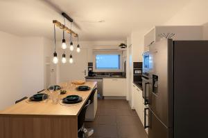 a kitchen with a island in the middle of a room at T3 moderne- Climatisé avec Parking & Terrasse à 5 min de Montpellier in Saint-Jean-de-Védas