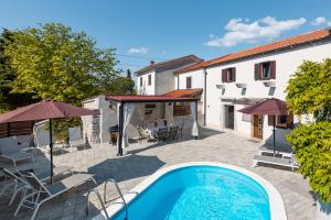 a swimming pool in front of a house at Villa Franka with heated pool in Milohnići