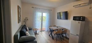 a living room with a couch and a table with chairs at App&Rooms Anica Kampor in Kampor