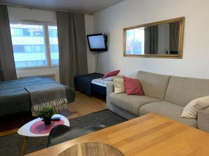 a living room with a couch and a bed at StarHomes City Studio B16 in Oulu
