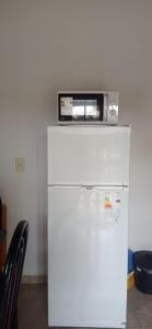 a microwave sitting on top of a refrigerator at Del Centro Dptos in Federación