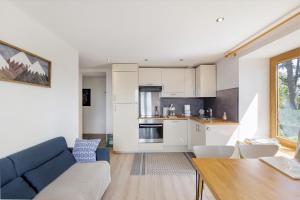 a living room with a blue couch and a kitchen at Lis Martagon in Font-Romeu