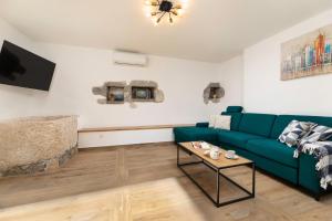 a living room with a blue couch and a table at Villa Franka with heated pool in Milohnići