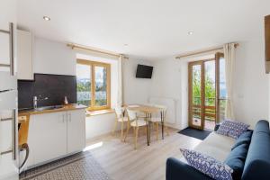 a kitchen and a living room with a couch and a table at Lis Martagon in Font-Romeu