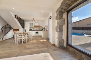 a kitchen and dining room with a table and a window at Villa Franka with heated pool in Milohnići