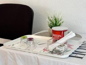 a tray with glasses and a can on a table at Rooms Feme in Trogir