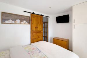 a bedroom with a bed and a wooden door at Sorbier Des Oiseaux in Font-Romeu