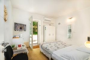 a white bedroom with a bed and a mirror at Rooms Feme in Trogir