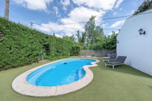 a swimming pool with a chair next to a building at Casa El Mure in Ronda