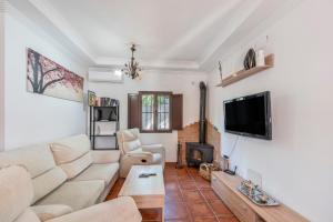 a living room with a white couch and a fireplace at Casa El Mure in Ronda