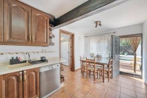 a kitchen with wooden cabinets and a table with chairs at Casa El Mure in Ronda