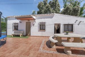 a white house with a patio and a table at Casa El Mure in Ronda