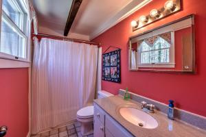 a bathroom with a sink and a toilet and a mirror at Sun Serenity at A Wave From It All in Pocasset +19 photos