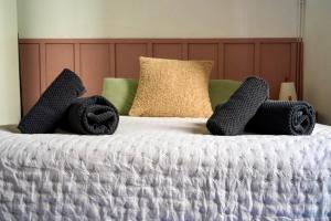 a bed with two black slippers and two towels at L'Escapade Mussipontaine in Pont-à-Mousson +7 photos