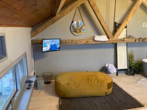a room with a large yellow ottoman in the corner of a room at The Stable Sleeps 2 with Parking in Llanfairpwllgwyngyll