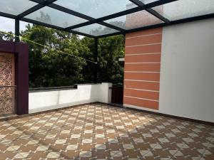 an empty patio with a glass door and a tile floor at Solace in Coimbatore