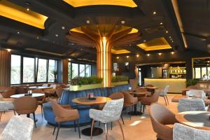 a restaurant with tables and chairs and a bar at Motel Adut Boleč in Donja Kapija