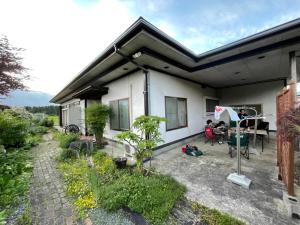 a group of people sitting on the patio of a house at 民泊ごとう in Kitakami